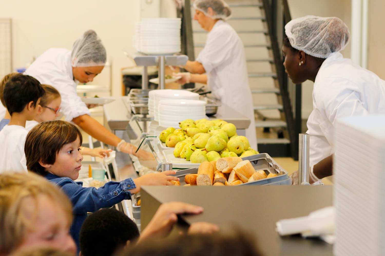 Des enfants en train de se servir au self de la cantine de l'école.