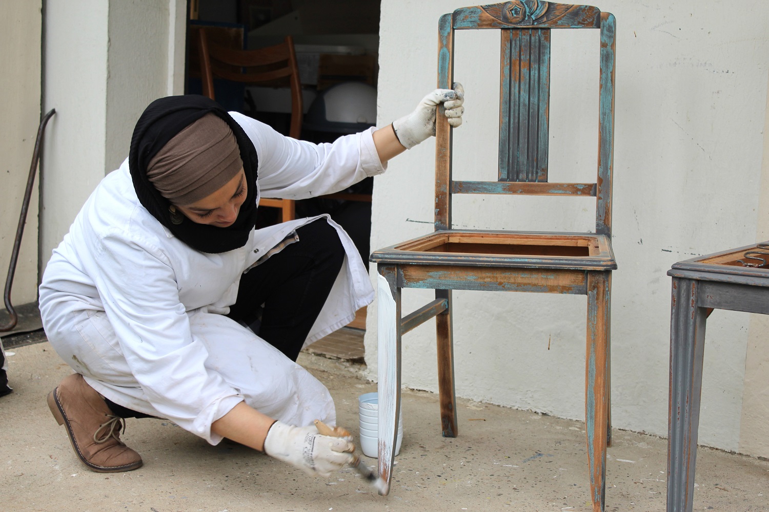 Saliha Radi rénovant des chaises