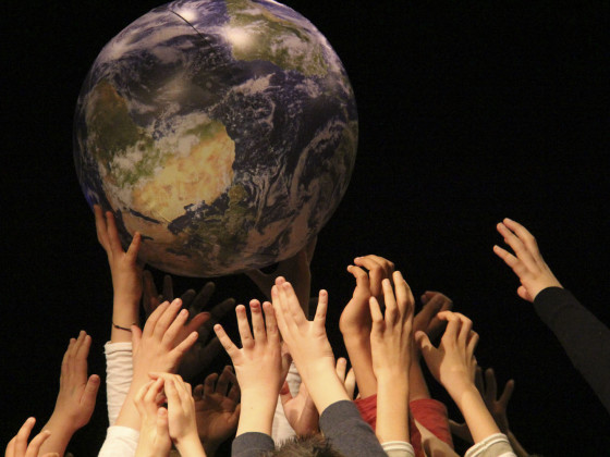 Photo de la Terre soulevée par des mains d'enfants 