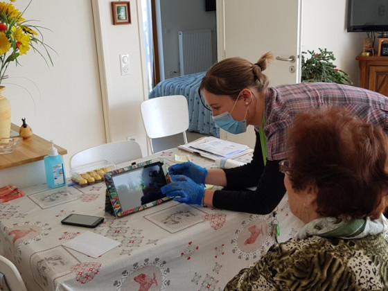 Une animatrice accompagne une résidente pour un visio rendez-vous avec sa famille
